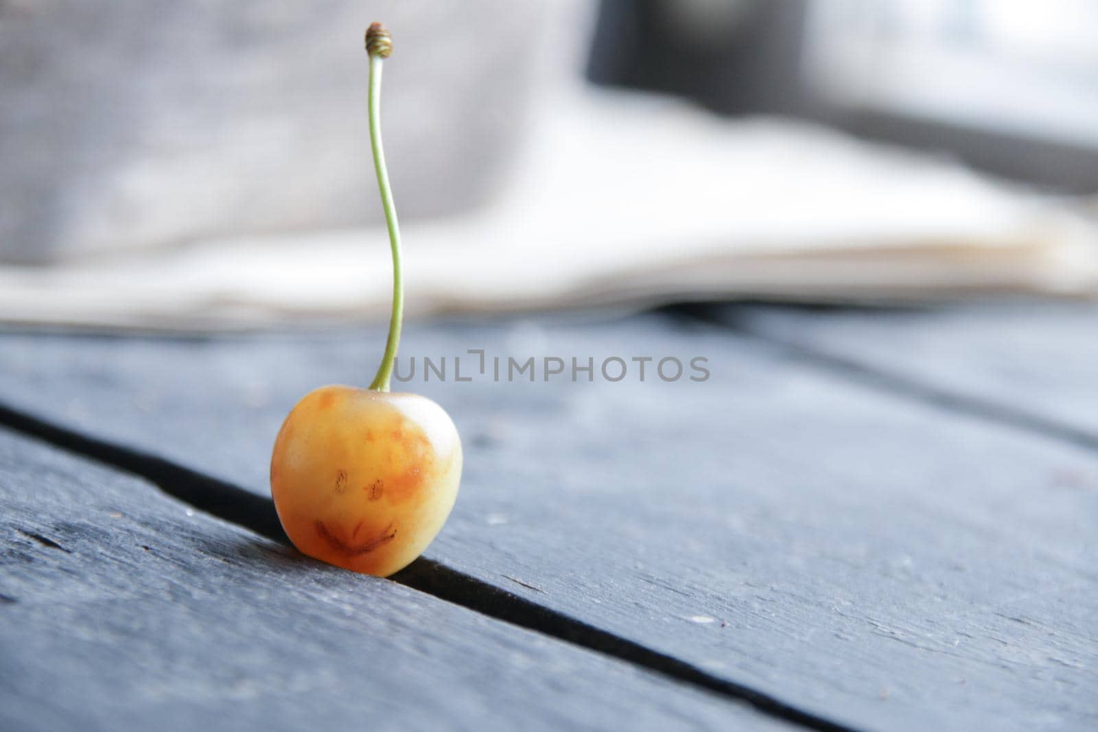 Advertising background. Yellow cherry with a painted smile. Place for text.