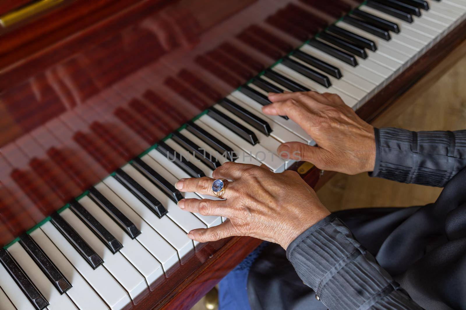Close-up, hands of an old woman playing the piano
