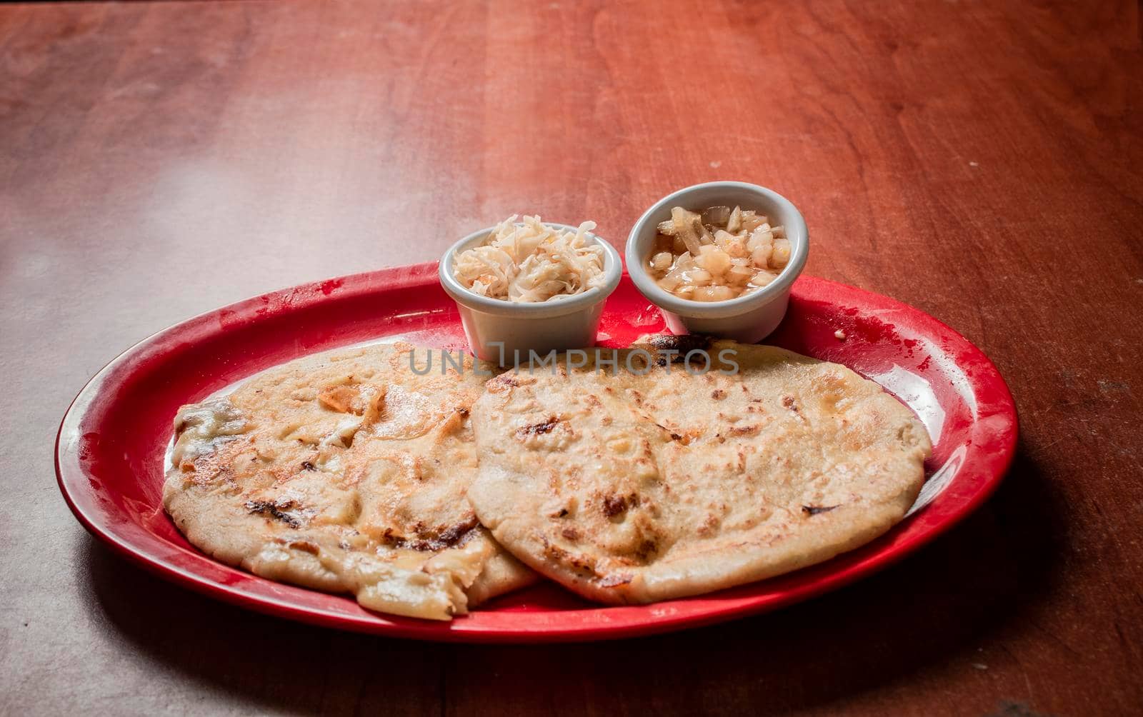 Traditional pupusas served on a wooden table, Closeup of Nicaraguan pupusas served on wooden table. Delicious traditional Salvadoran Pupusas with melted cheese on wooden table