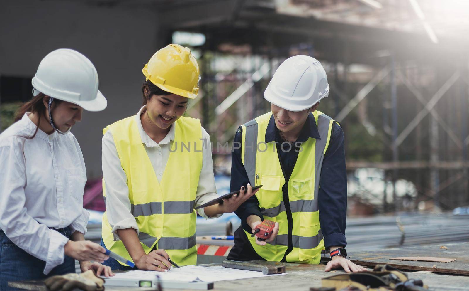 Three experts inspect commercial building construction sites, industrial buildings real estate projects with civil engineers, investors use laptops in background home, concrete formwork framing. by wichayada