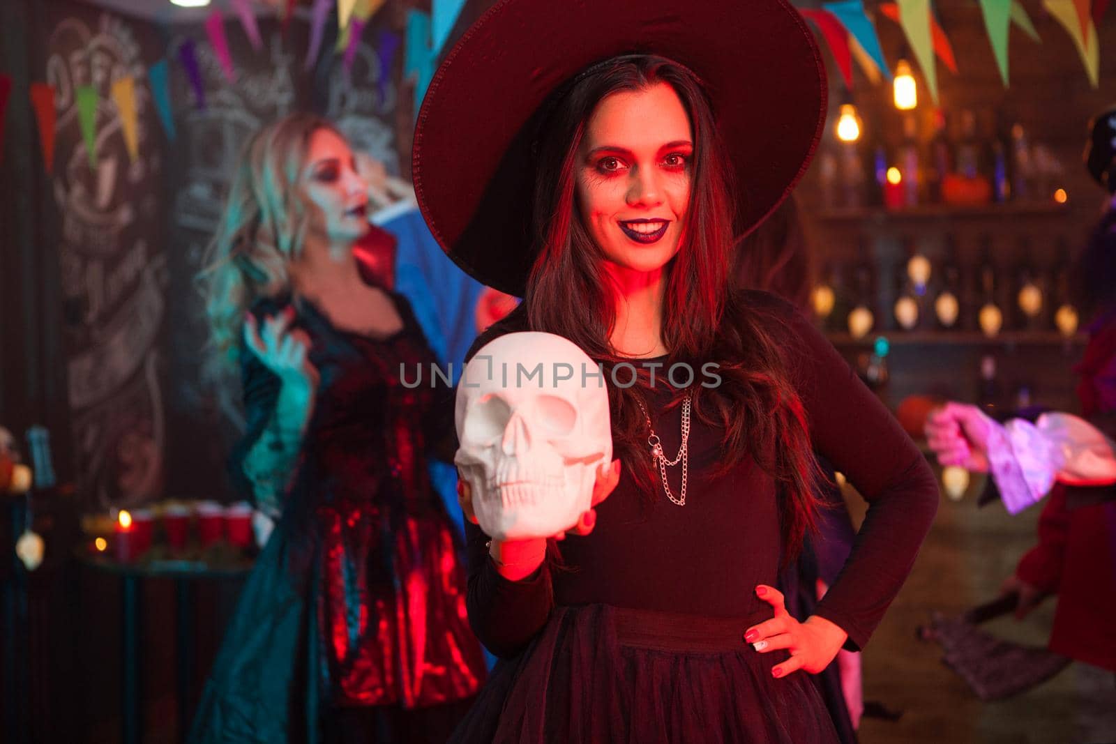 Portrait of beautiful girl with a big hat dressed up like a witch for halloween celebration by DCStudio