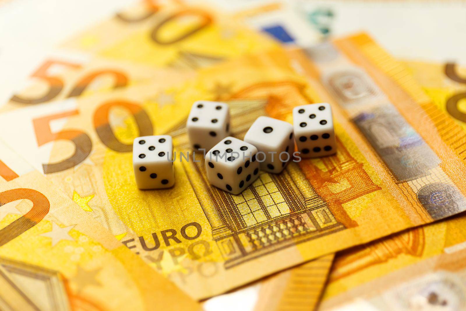 White Gaming dice and money on dark table. by InnaVlasova