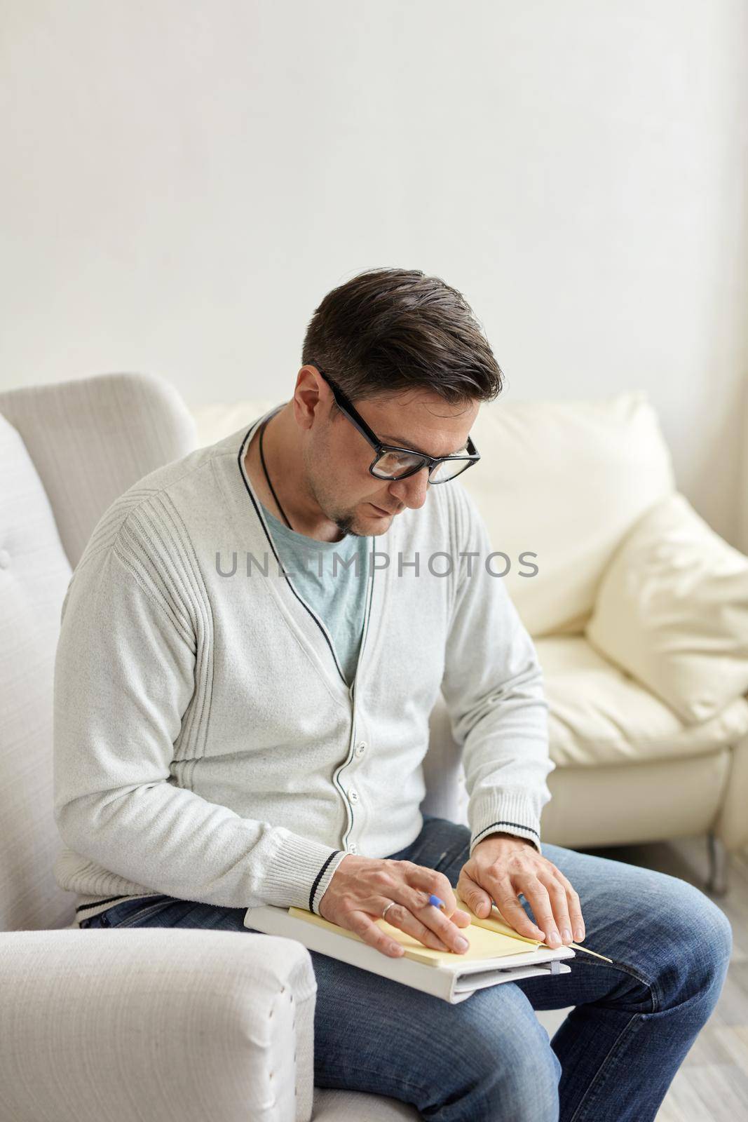 Waiting for patient. Friendly psychologist sitting with clipboard, in office, empty space