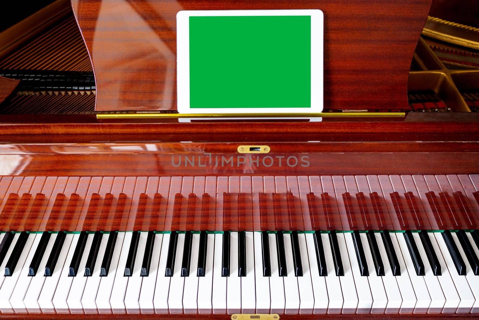 Close-up, on the piano a sign with an empty space, copy space, copy paste. Chroma key green. Cover concept for music festival, concert. Tutorial for musicians online