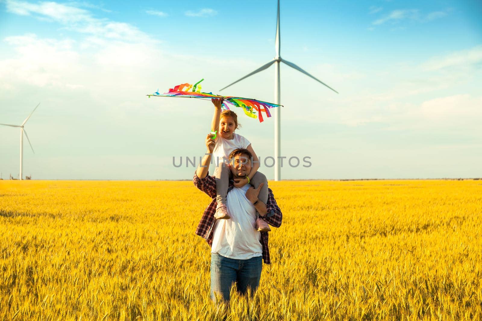 Father and daughter having fun, playing with kite together on the Wheat Field on Bright Summer day by InnaVlasova