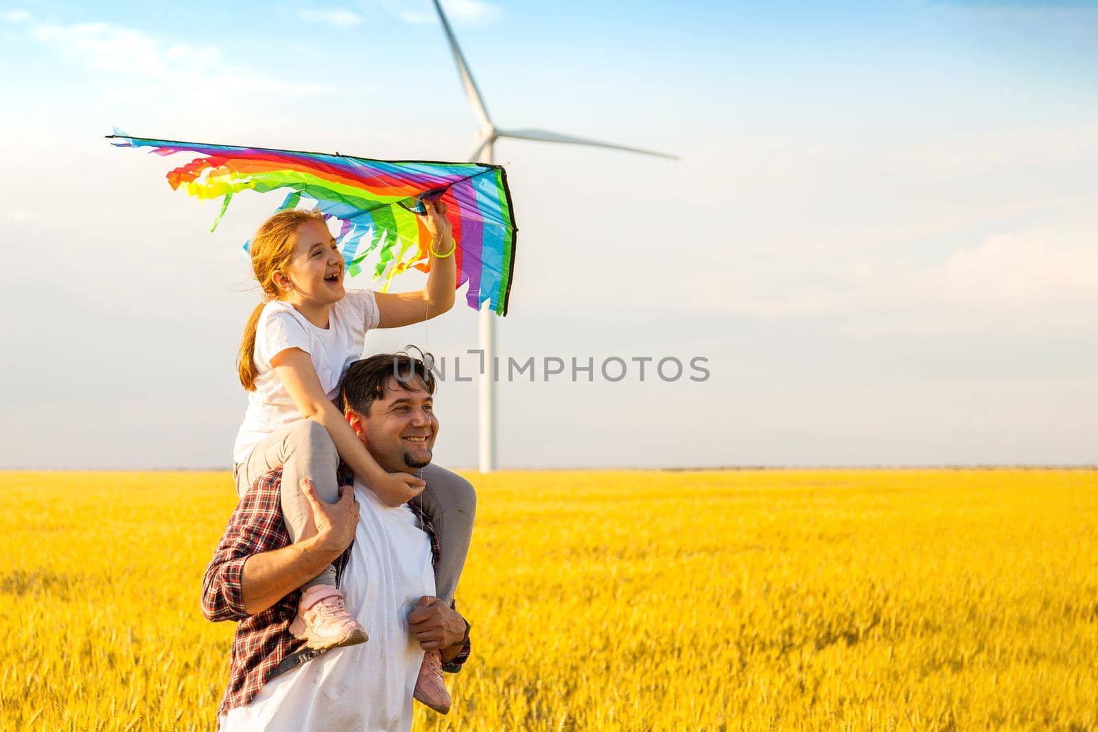 Happy father's day. Father and daughter having fun, playing with kite together on the Wheat Field on Bright Summer day