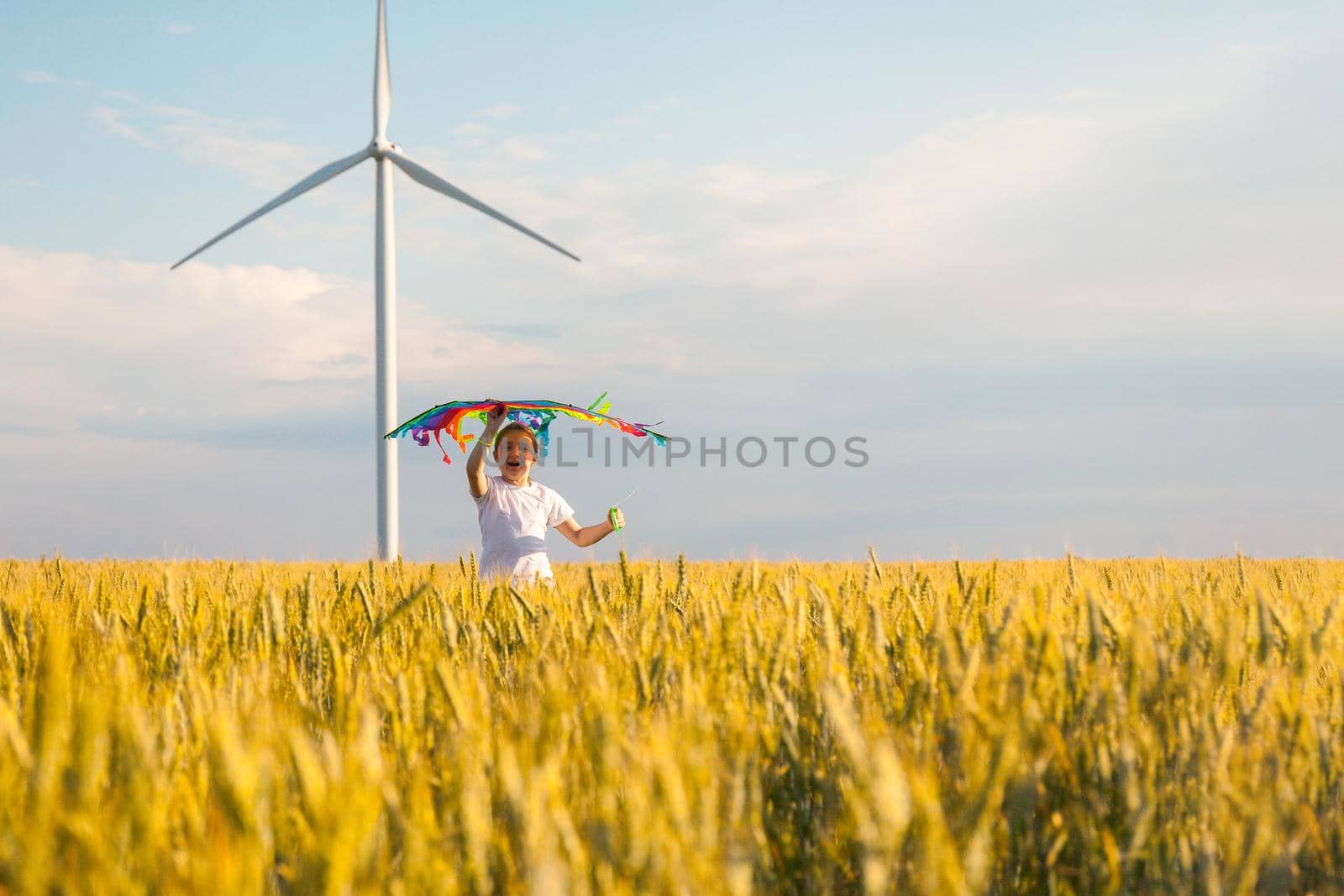 Happy Little girl running in a wheat field with a kite in the summer. by InnaVlasova