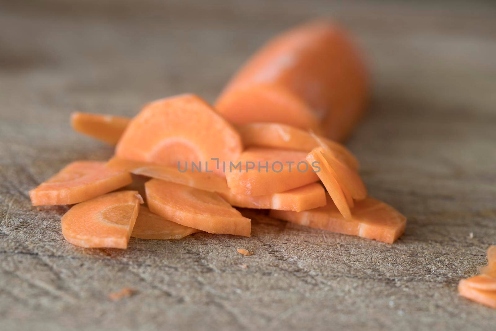 Close up of slices of carrot on cutting board.