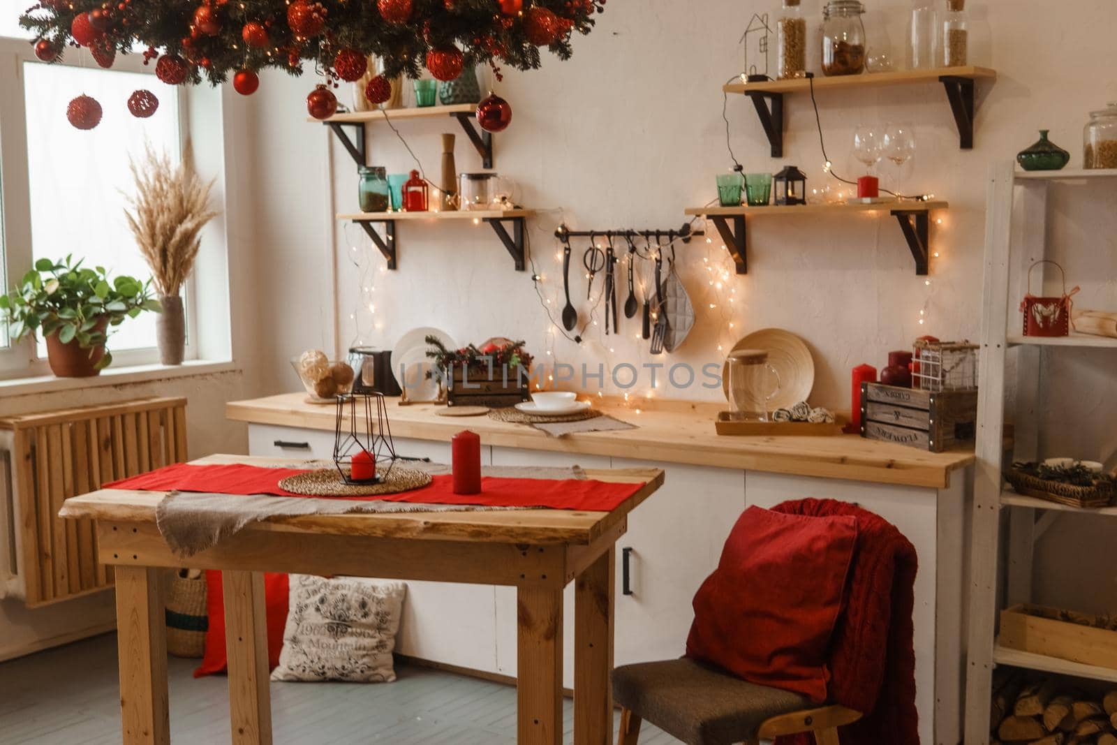 The kitchen is decorated in a Christmas style with red accents. Cozy atmosphere of winter holidays.