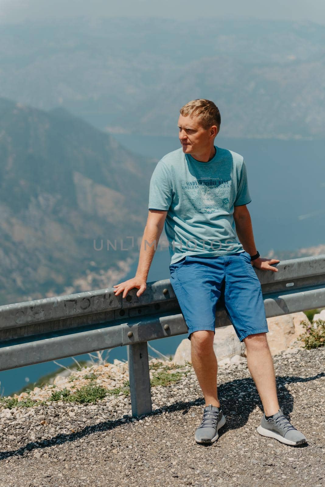 Man tourist enjoys the view of Kotor. Montenegro. Bay of Kotor, Gulf of Kotor, Boka Kotorska and walled old city. Travel to Montenegro concept. Fortifications of Kotor is on UNESCO World Heritage by Andrii_Ko