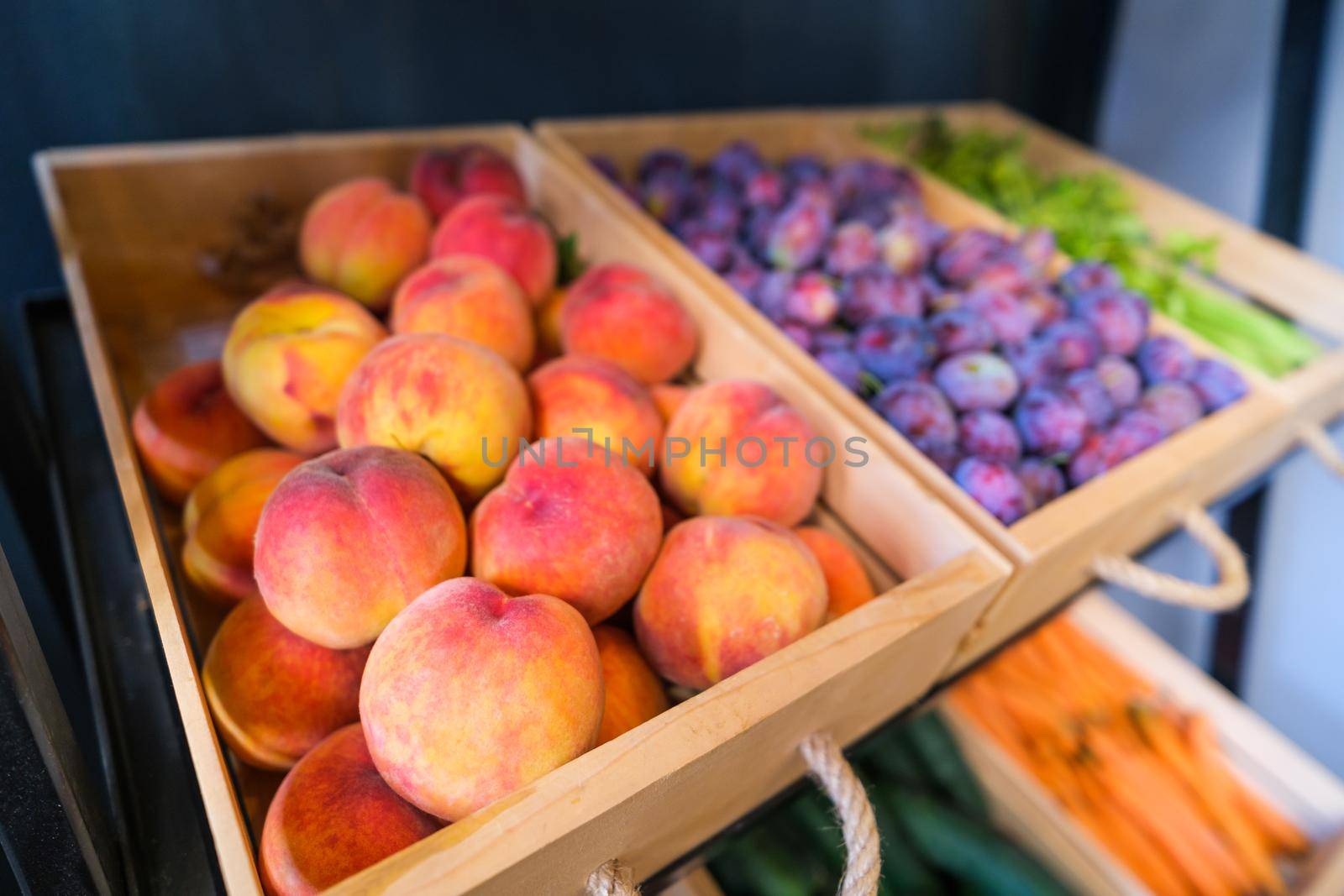 Healthy fruit and vegetables in grocery shop. Close up of basket with peaches in supermarket.