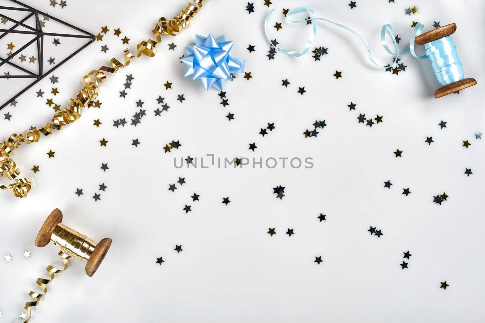Delicate wavy ribbons and metallic star shaped confetti isolated on white background. Christmas holidays decoration concept. Perfect backdrop for your design.