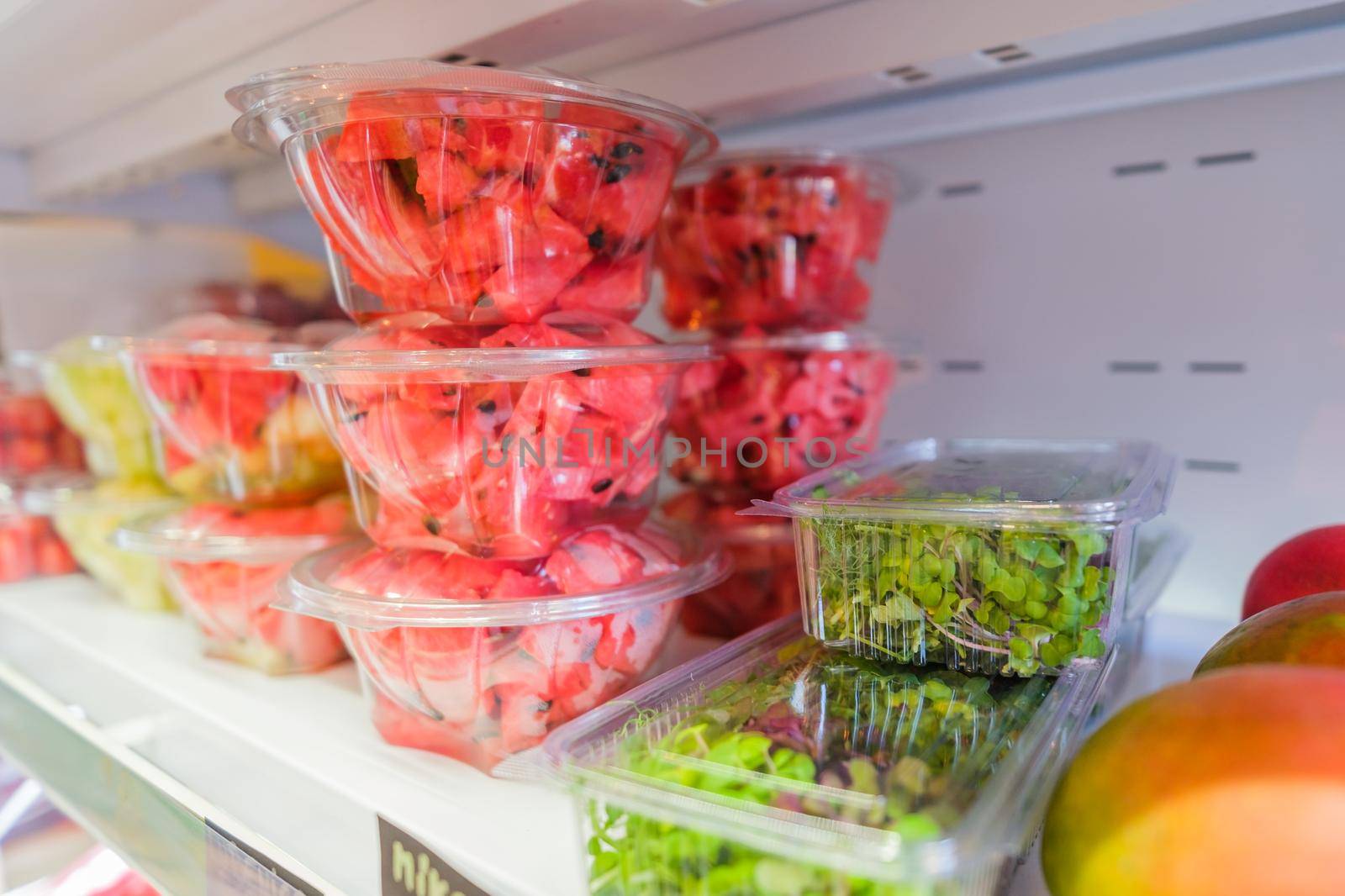 Healthy fruit and vegetables in grocery shop. Close up of fresh food in refrigerator.