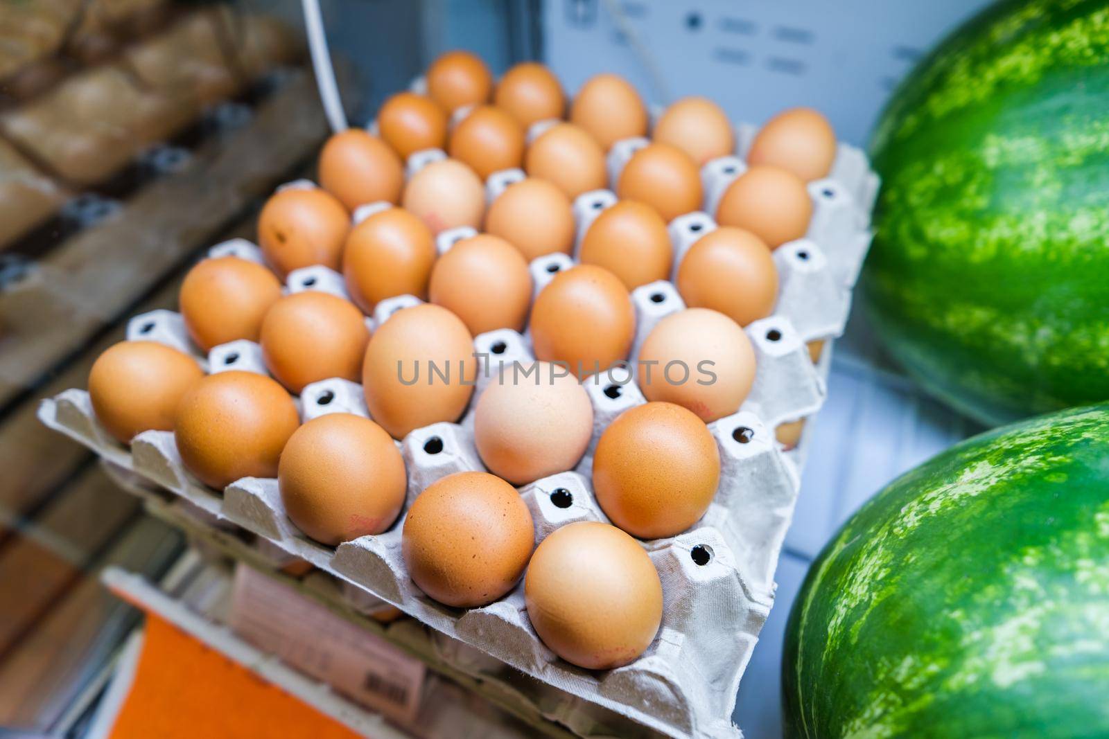 Healthy fruit and vegetables in grocery shop. Close up of basket with eggs in refrigerator.