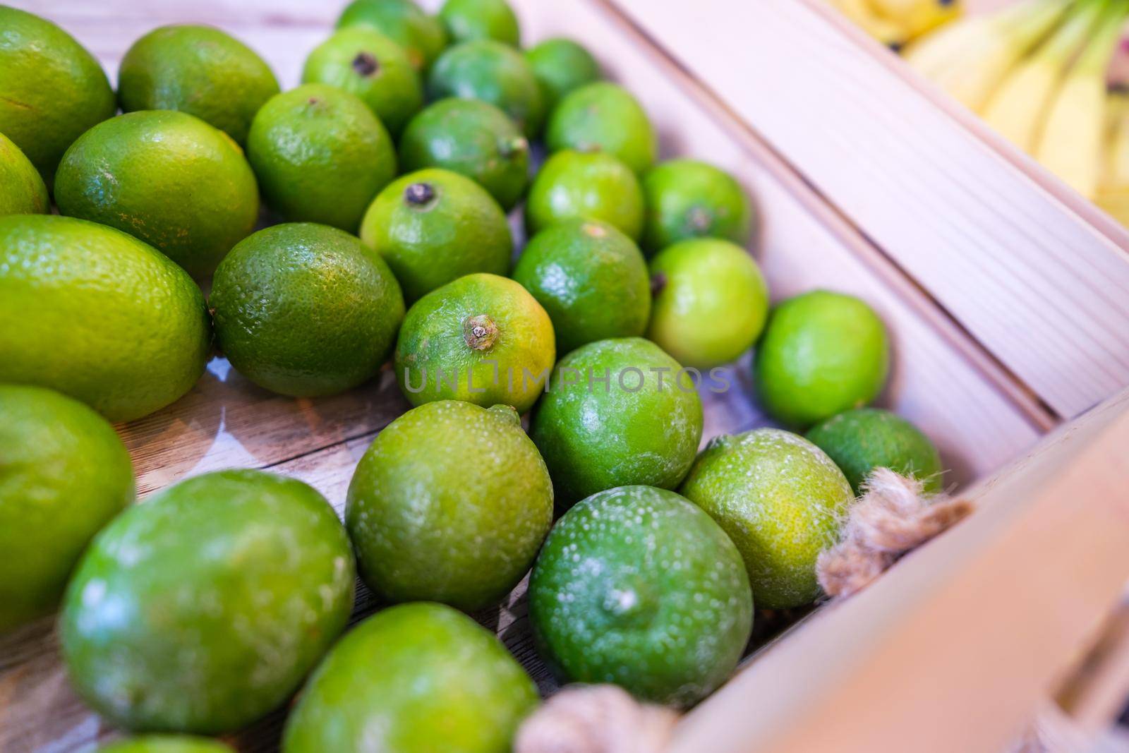 Close up of basket with lime fruit in supermarket.