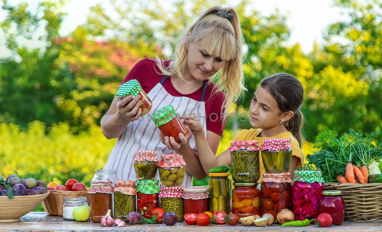 Woman with jar preserved vegetables for winter mother and daughter. Selective focus. Food.