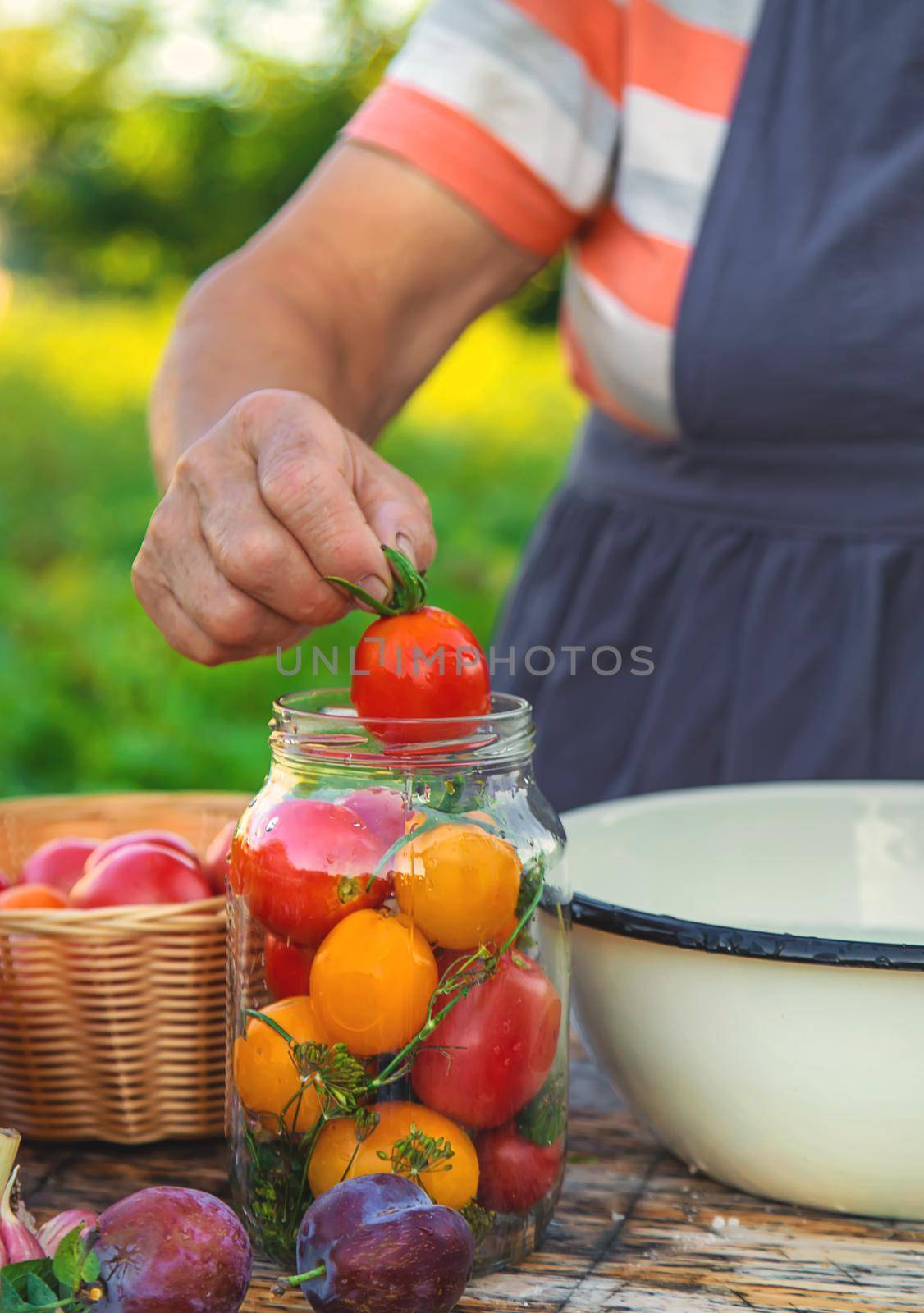 Senior woman preserving vegetables in jars. Selective focus. Food.