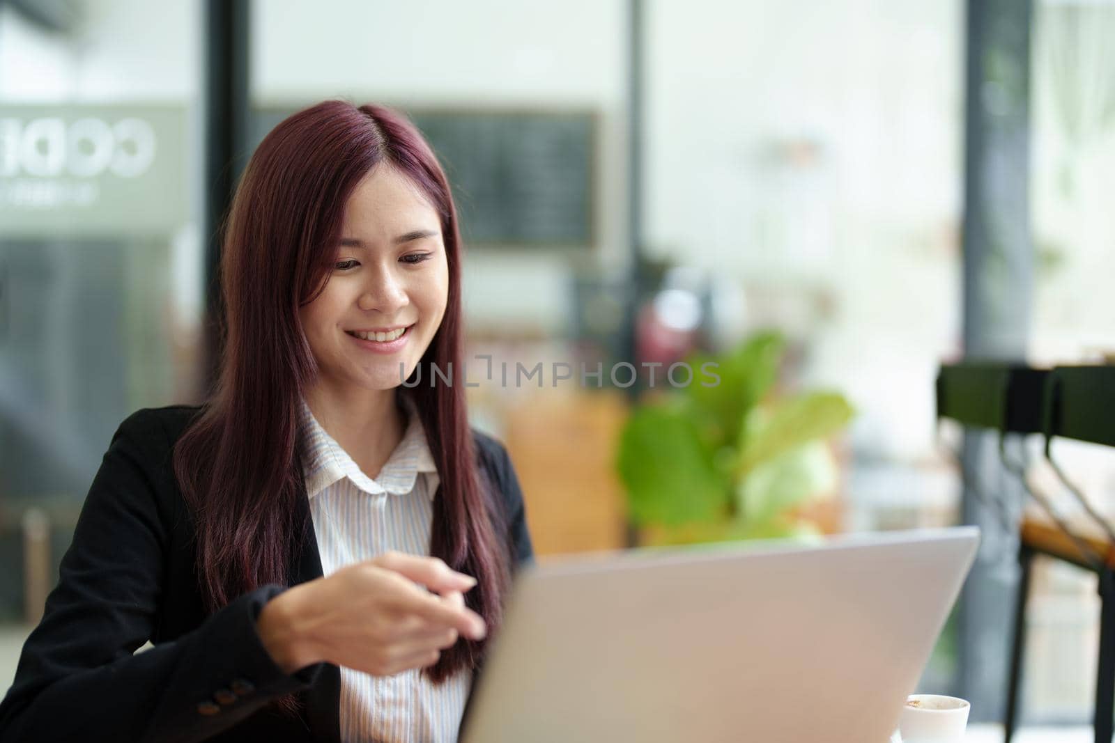 Portrait of a business woman using a computer to work on financial statements.