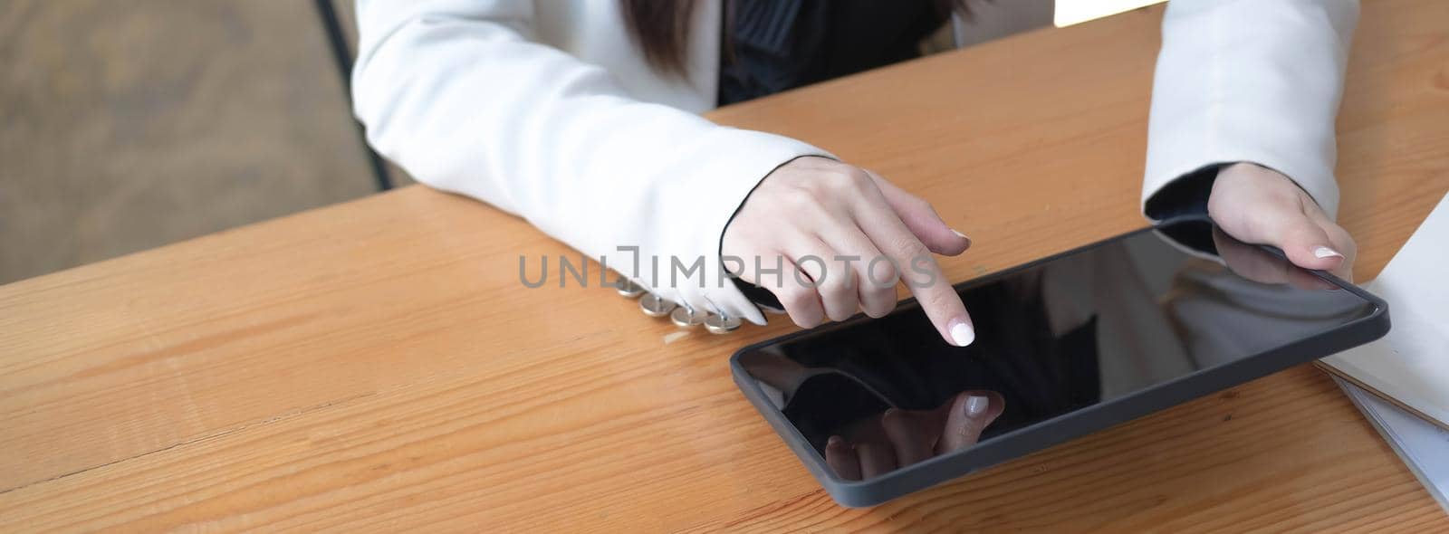 Woman touching on digital tablet screen, chatting in social networks, searching internet, sending sms, using text messenger or online banking. Close up view..