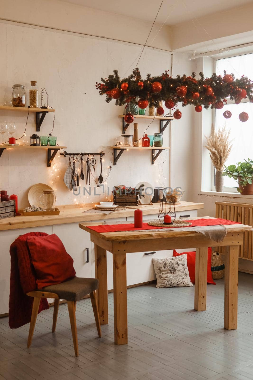The kitchen is decorated in a Christmas style with red accents. Cozy atmosphere of winter holidays.