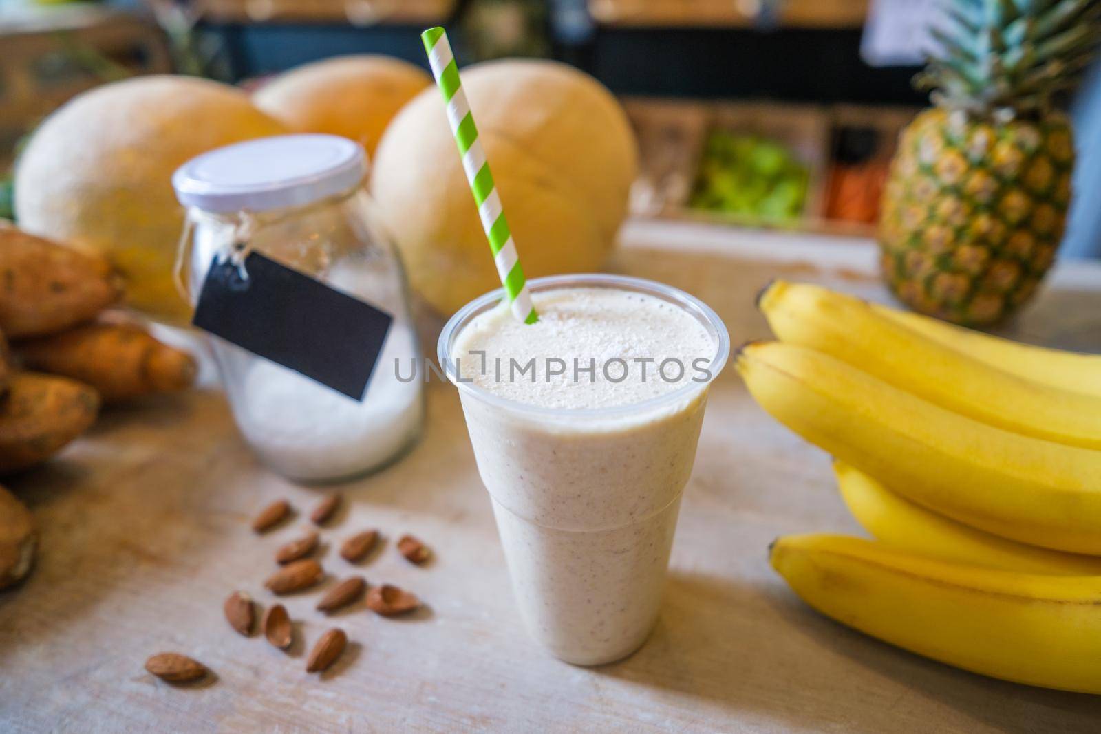 Healthy fruit shake on table with fruits and vegetables ingredients around.