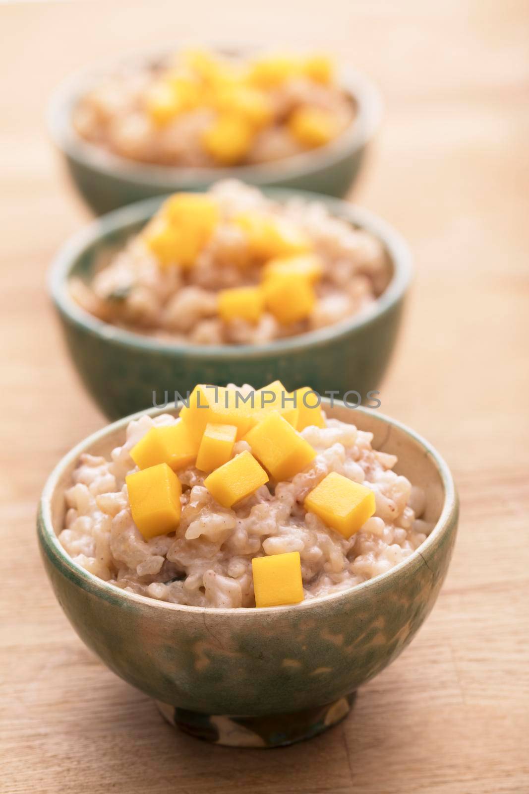 Delicious rice pudding in bowls topped with fresh mango.