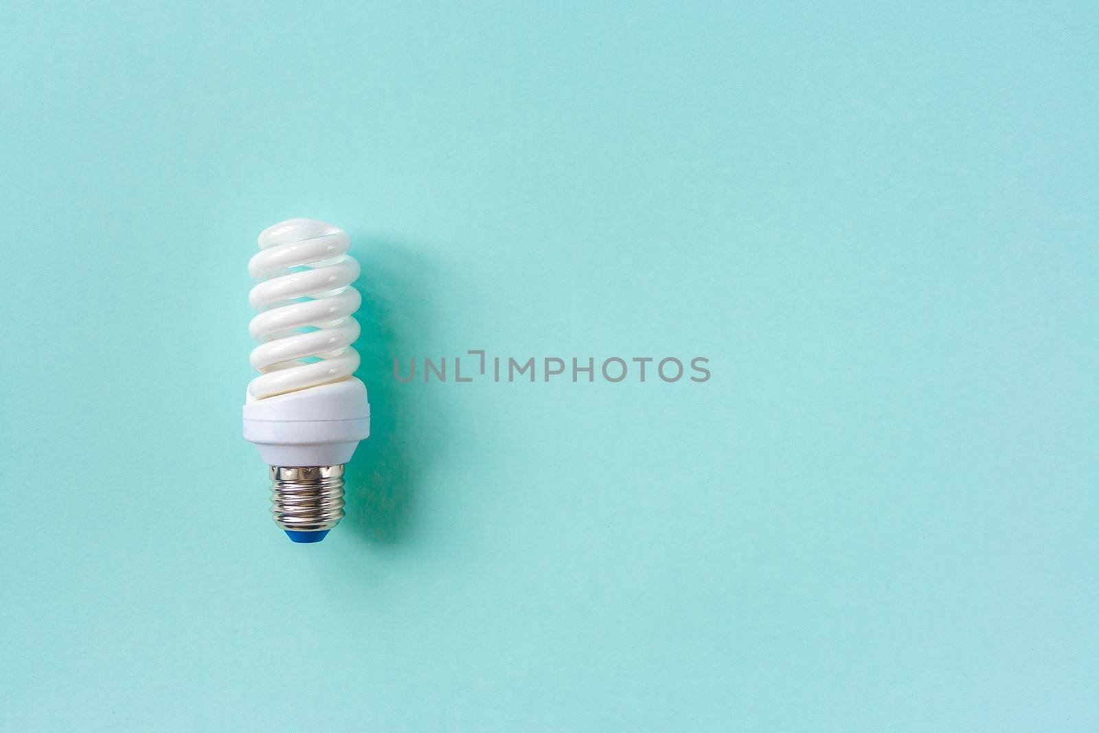 Energy saving light bulb on a blue background. Economical consumption of electricity. The concept of nature conservation