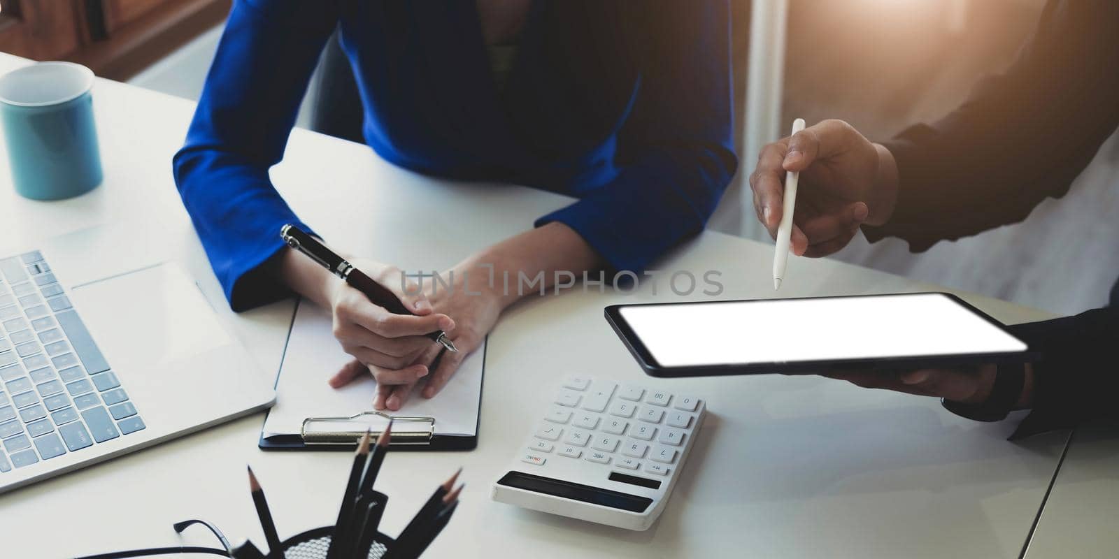 Entrepreneur Asian businessman and businesswoman discussing new business project in tablet in modern Meeting In Modern Office, Asian business casual concept..