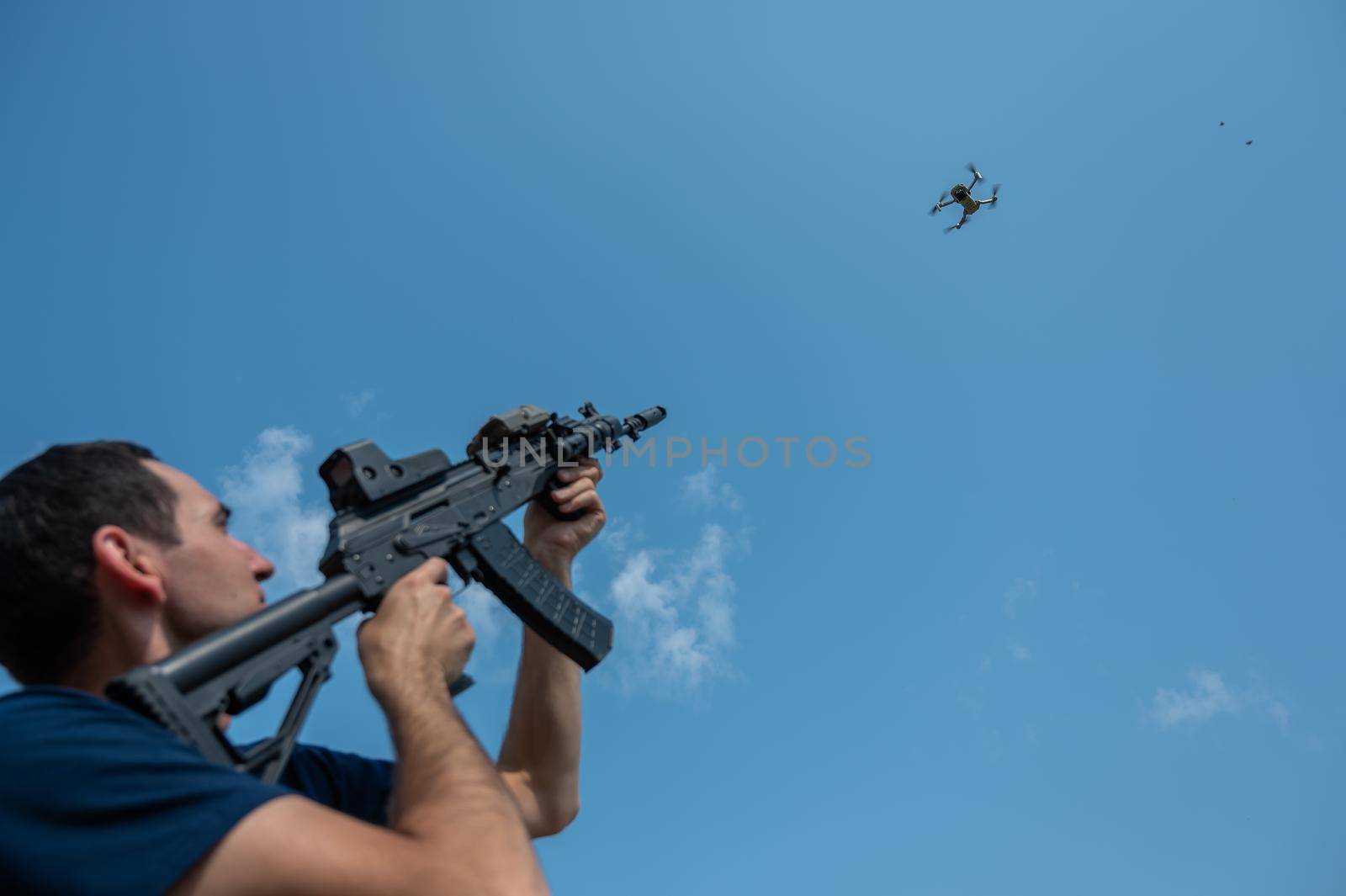 Caucasian man shoots a flying drone with a rifle