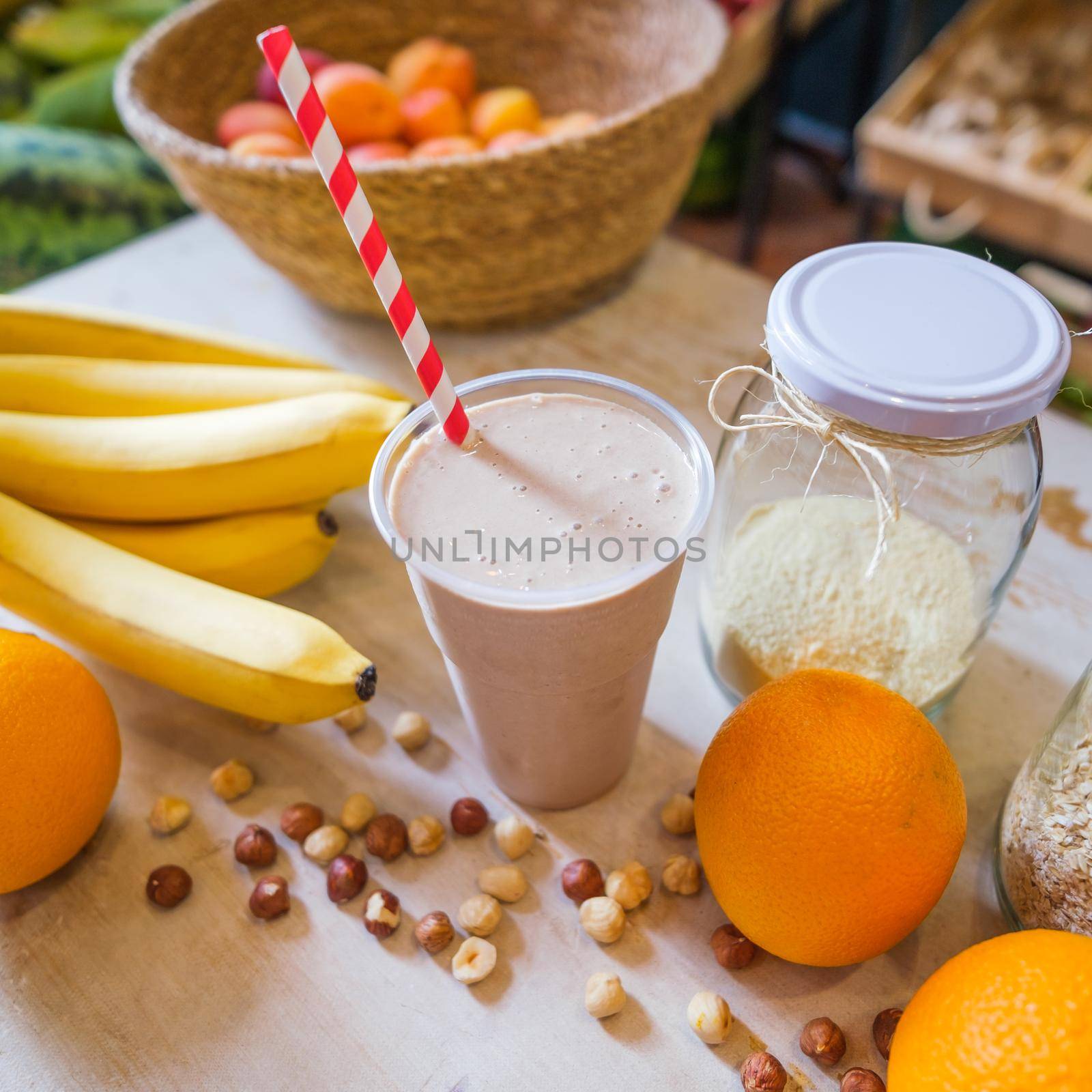 Healthy fruit shake on table with fruits and vegetables ingredients around.