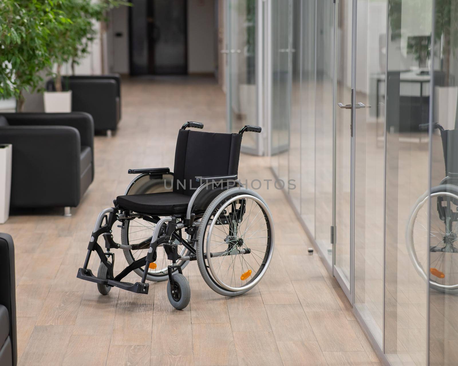 Empty wheelchair in the hallway in the office. by mrwed54