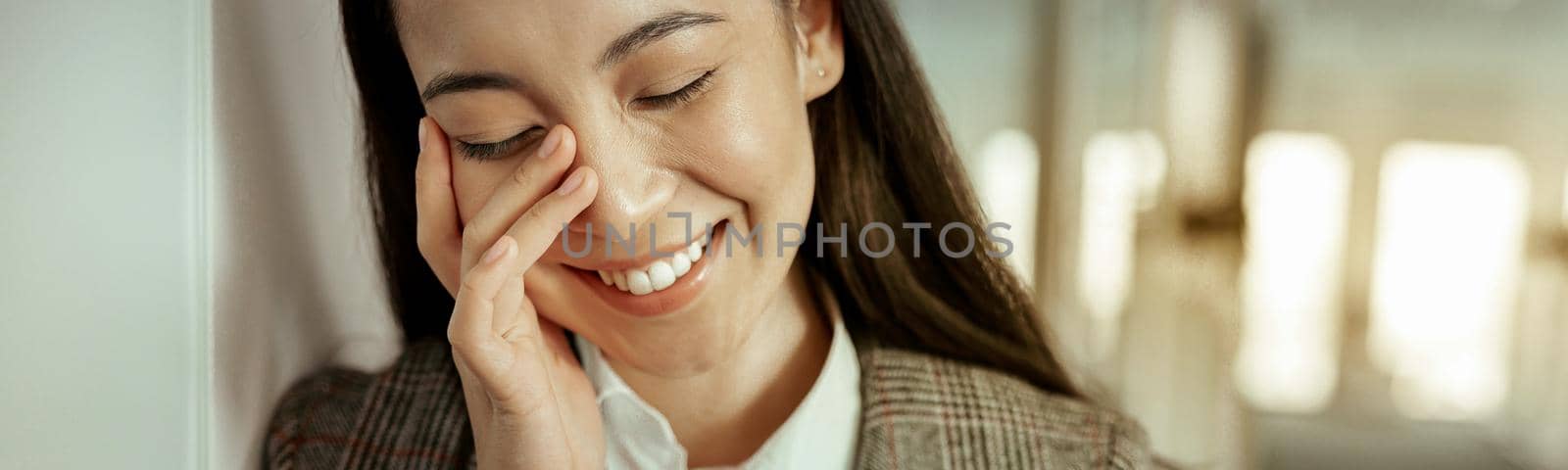 Close up of asian business woman making call and smiling standing at office. High quality photo