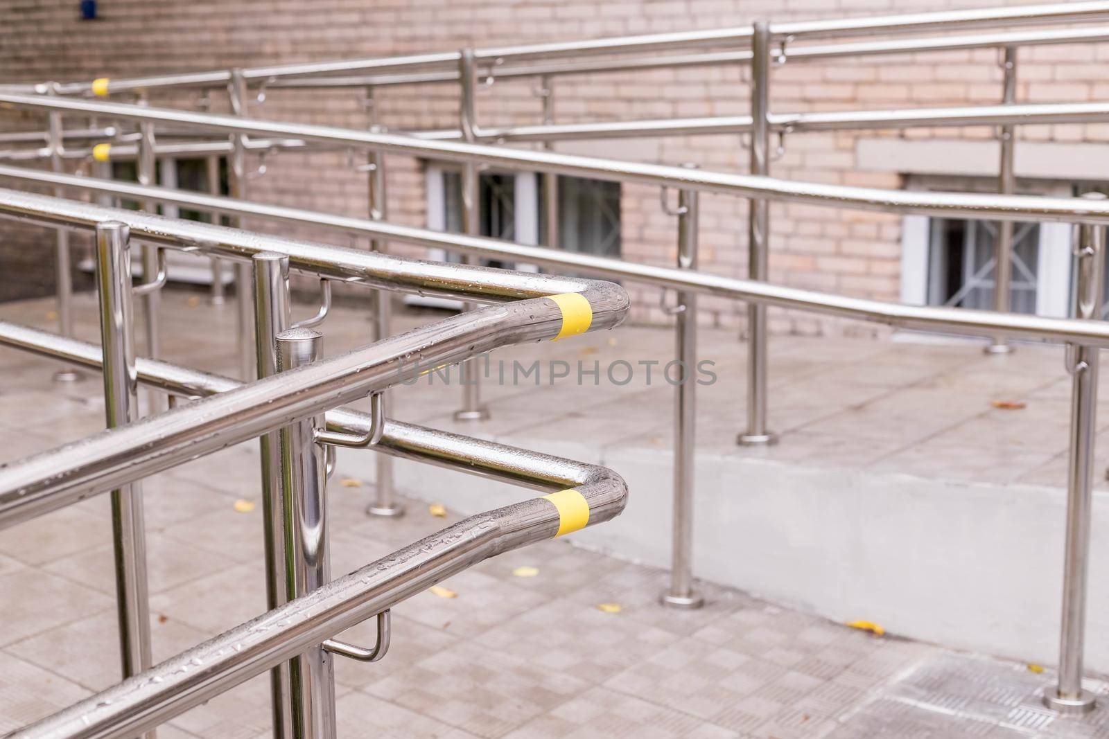 Way of wheelchair, concrete ramp way with stainless steel handrail with disabled sign on the floor for support wheelchair of disabled people and stairs for normal people.