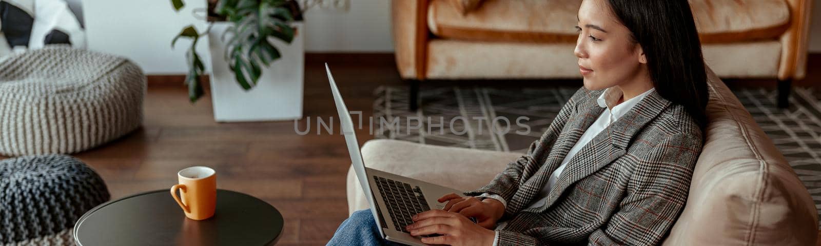 Attractive asian business woman working laptop sitting in cozy office. High quality photo