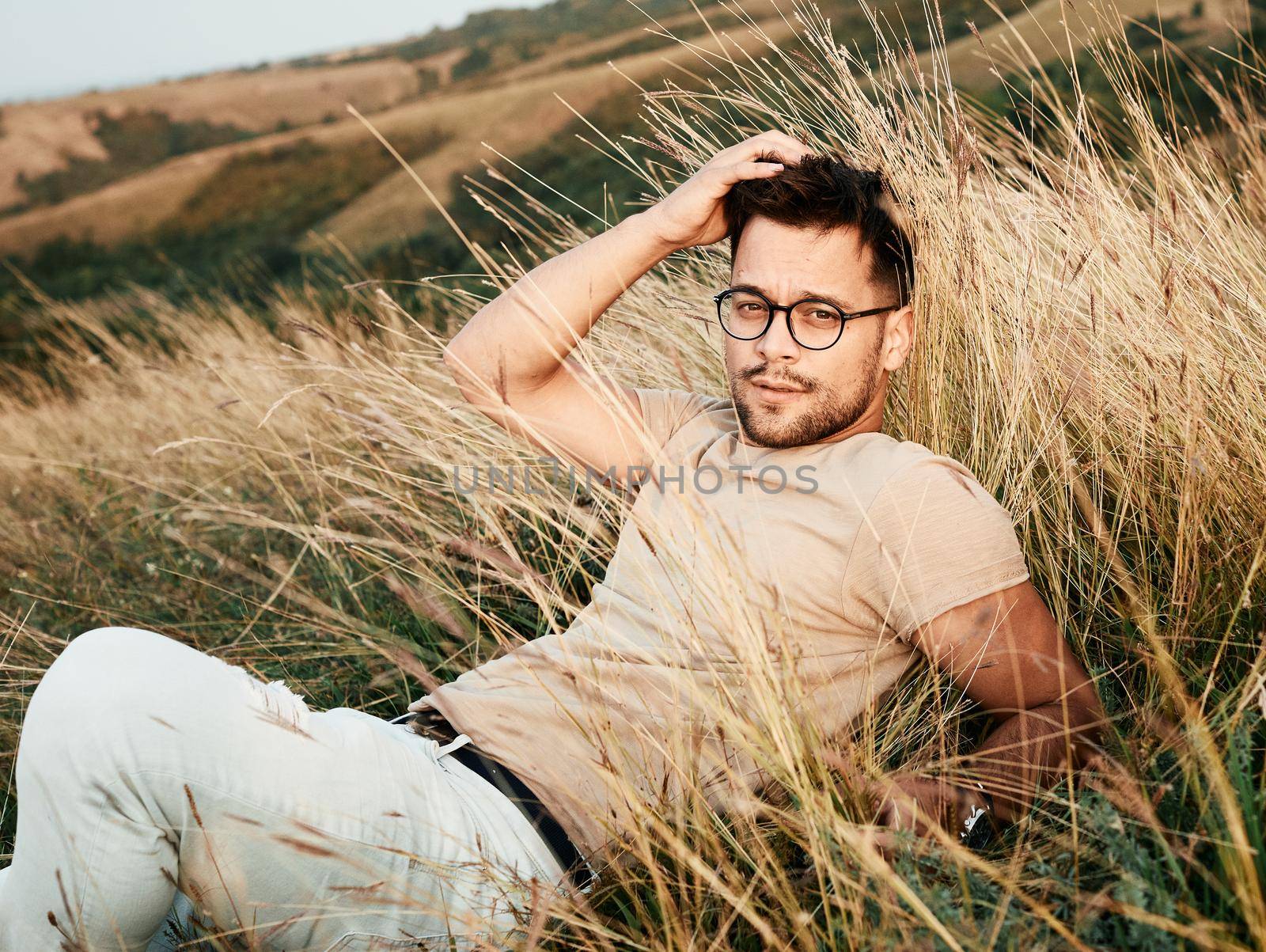 Portrait of a young man fashion model outdoors in the field