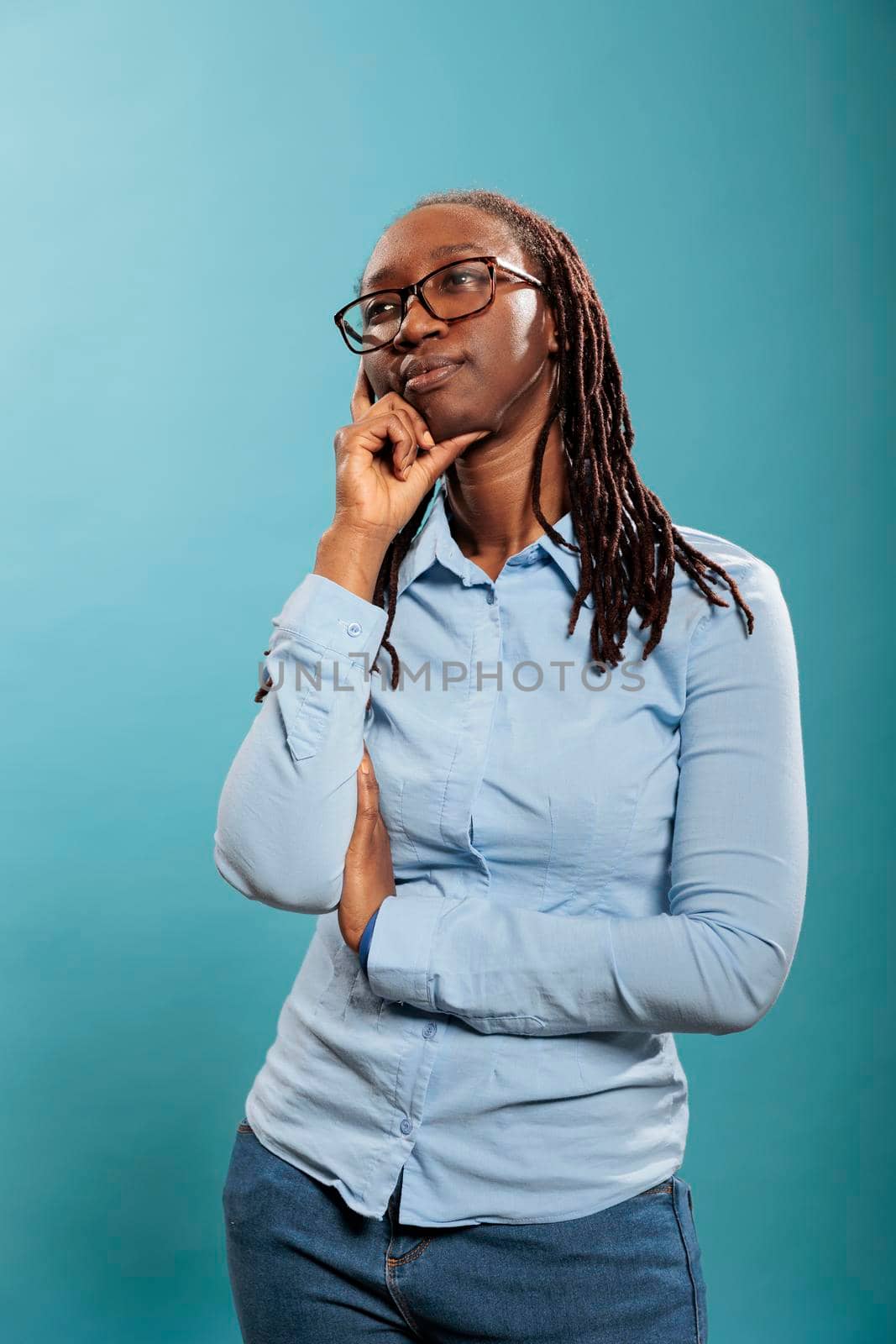 Pensive thoughtful african american woman being meditative and introspective on blue background. by DCStudio