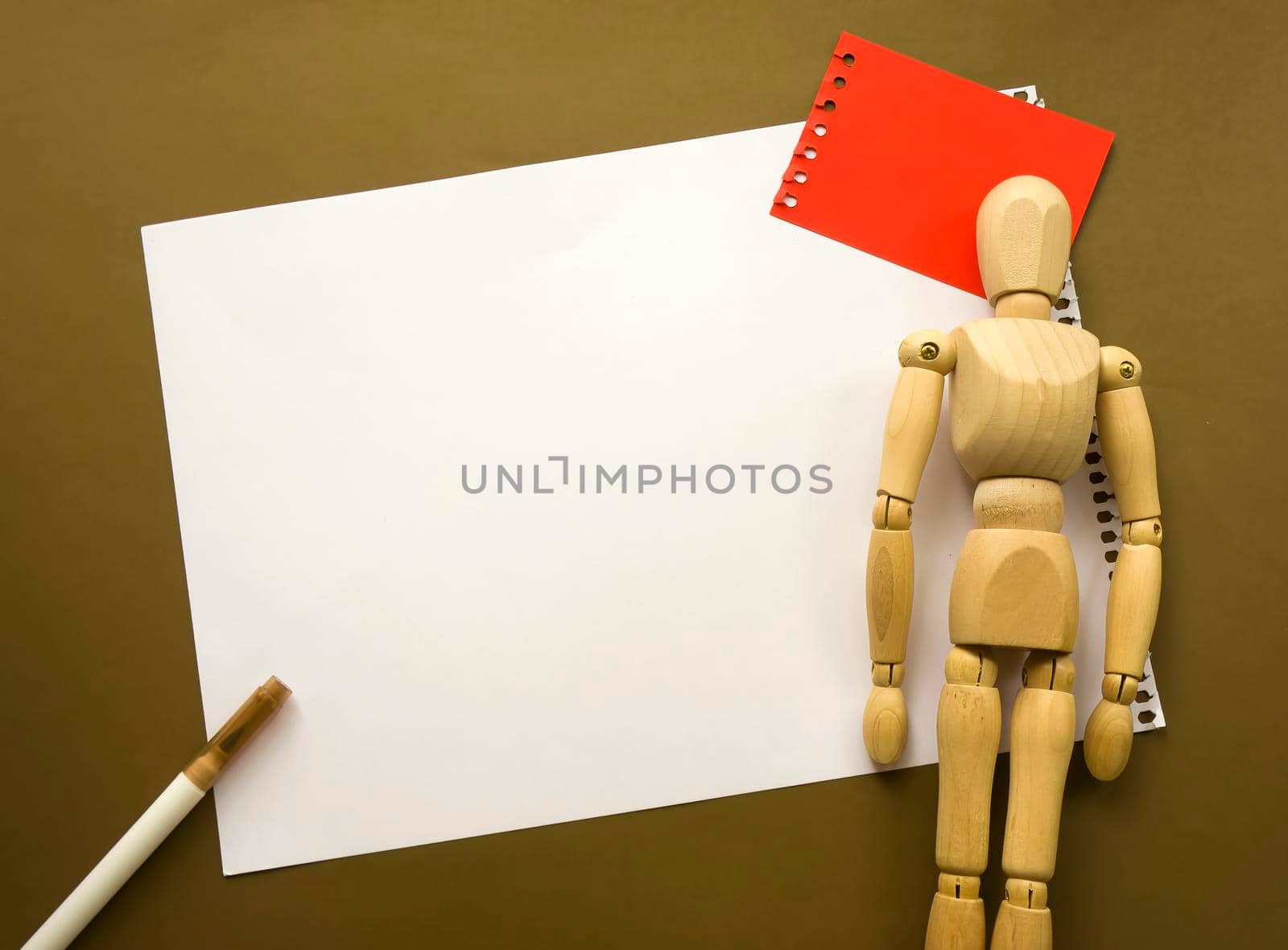 Wooden doll and a blank piece of paper. Wooden mannequin with sheets of paper concept, blank space. Creativity and art