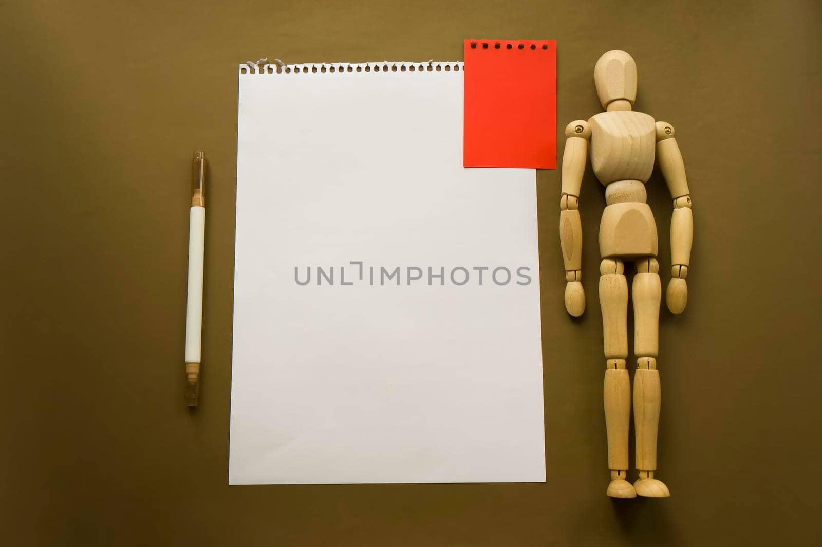 Wooden doll and a blank piece of paper. Wooden mannequin with sheets of paper concept, blank space. Creativity and art