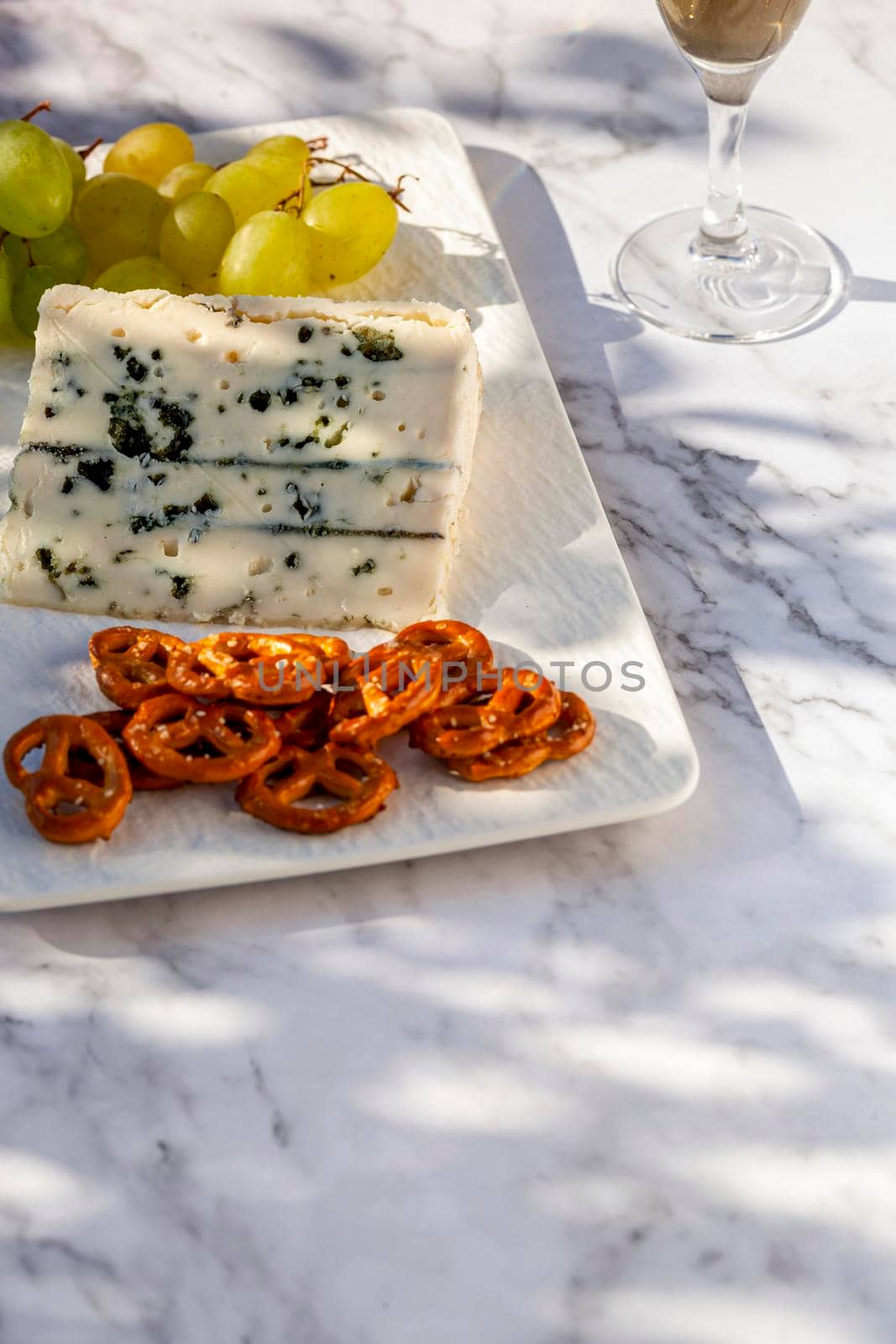 gorgonzola cheese served outdoors with green grapes, snacks and wine, hard light