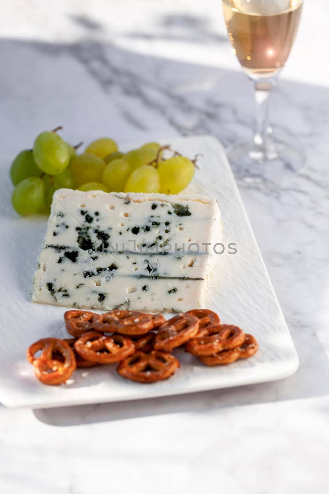 gorgonzola cheese served outdoors with green grapes, snacks and wine, hard light