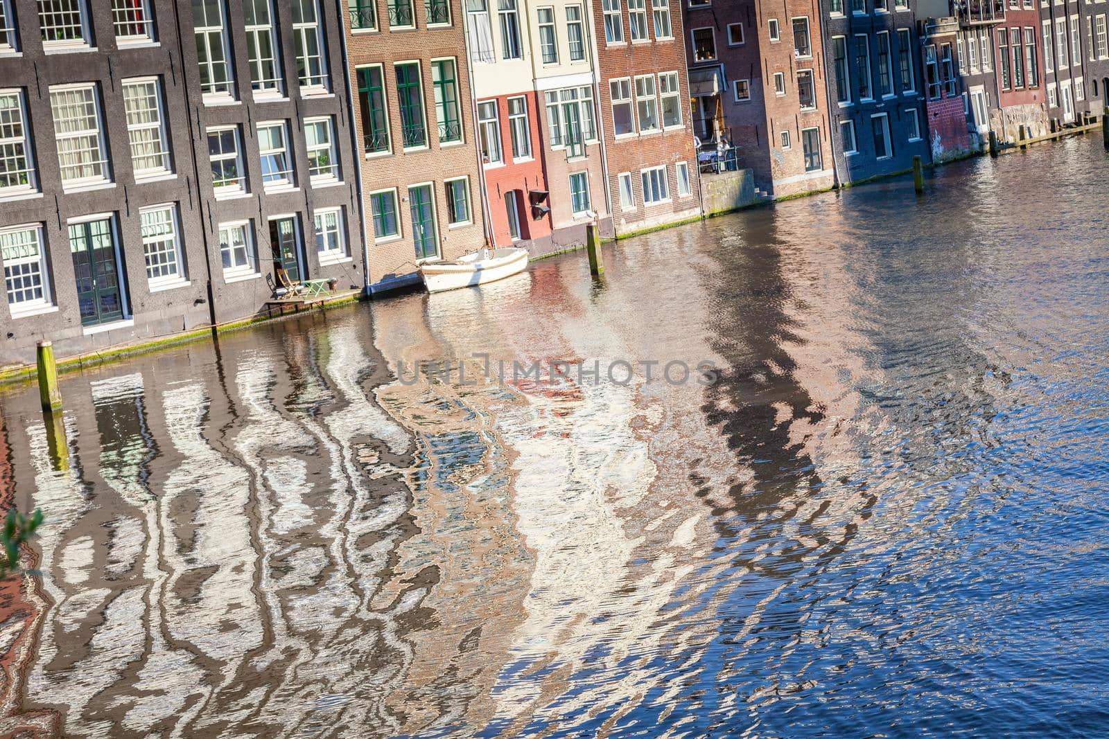 Amsterdam canal with houseboats and dutch architecture at sunrise, Netherlands