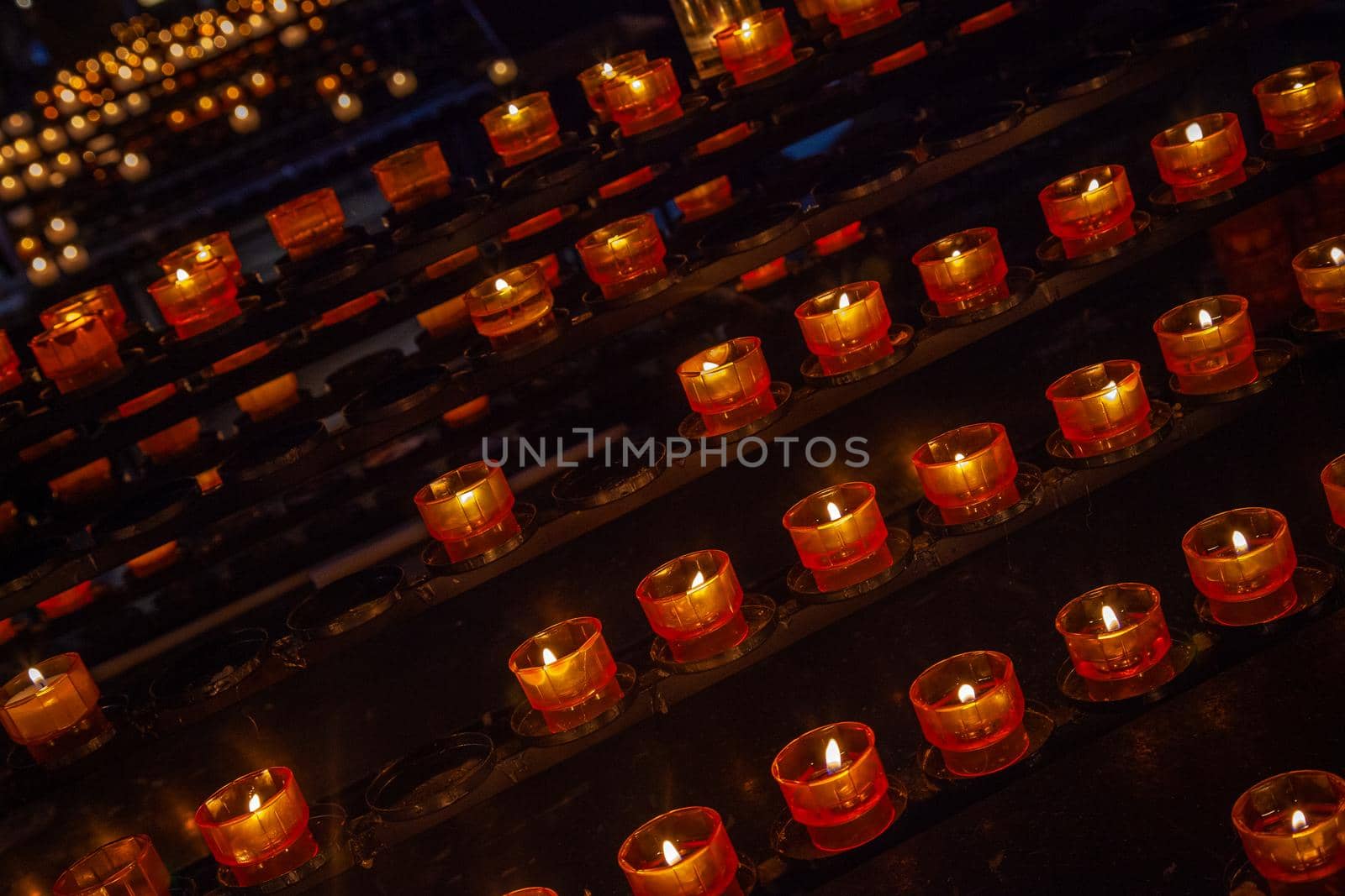 row of tea light candles burning inside Notre Dame Cathedral in Strasbourg, Eastern France