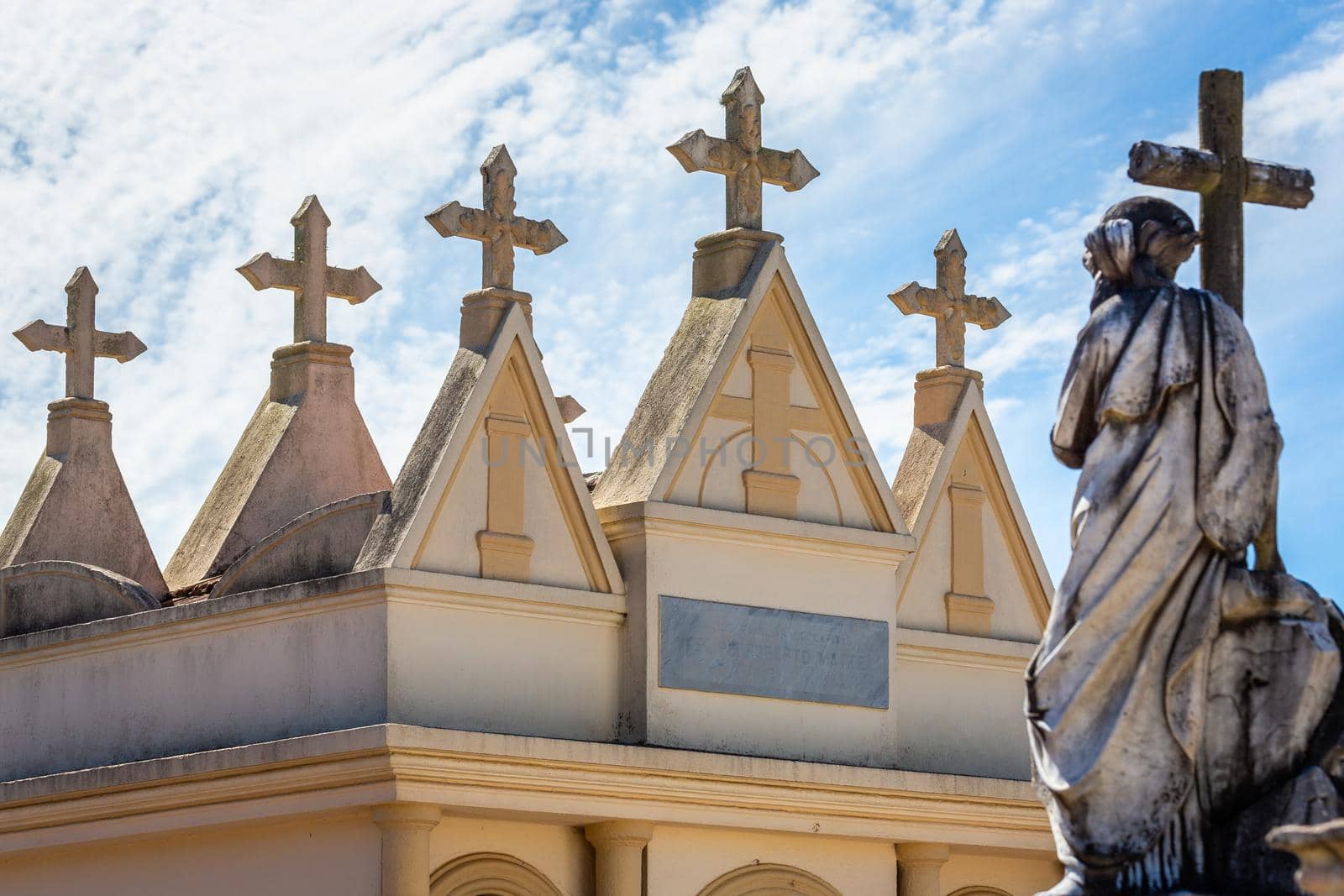 Pattern of crosses tombstones in Cemetery in a row and blue sky