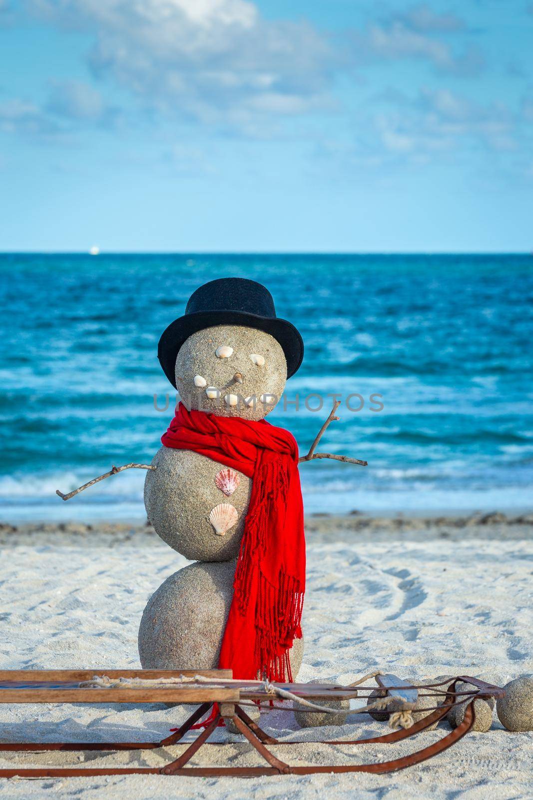 Snowman with red scarf, Hat and sled on the south Miami Beach, Florida