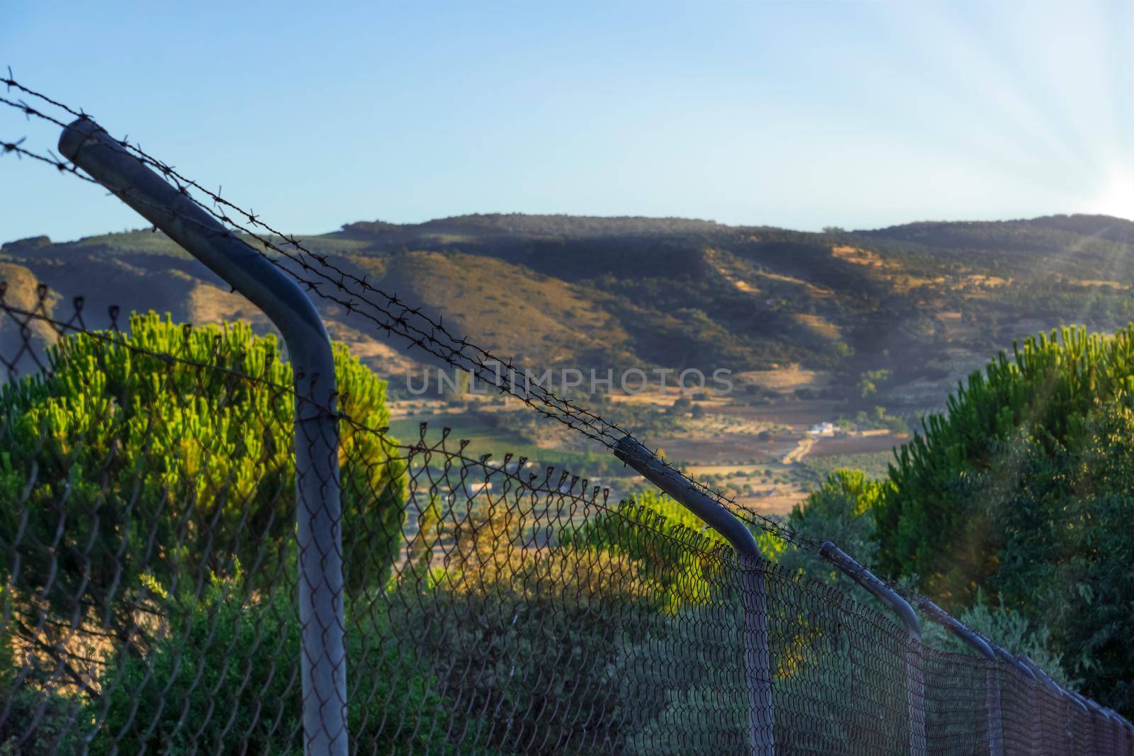 view of a barbed wire fence with mountains in the background by joseantona