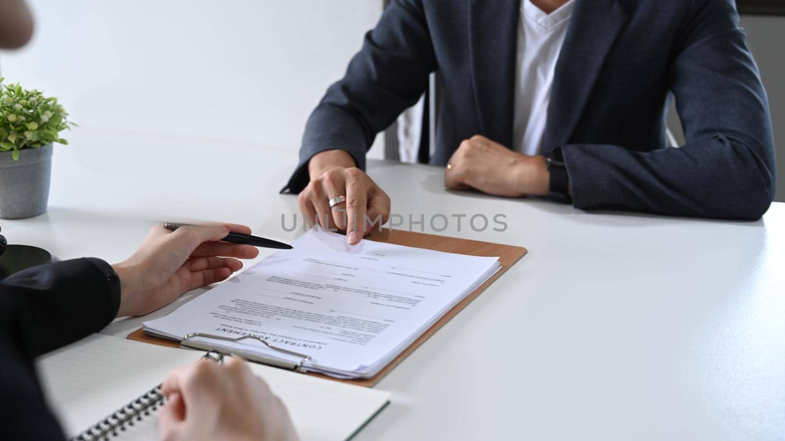 Cropped imaged of businessman discussing contract document with female lawyer of financial advisor.