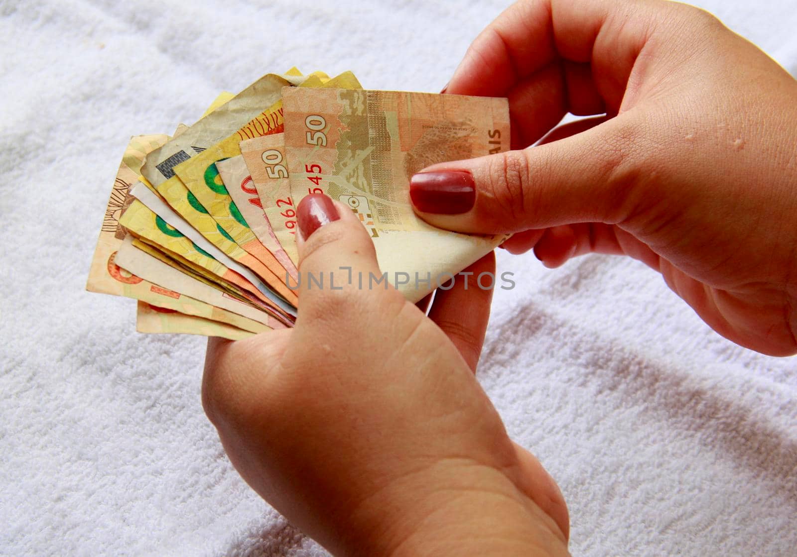 salvador, bahia / brazil - january 23, 2015: Woman hands counting Real, Brazilian money banknotes.

