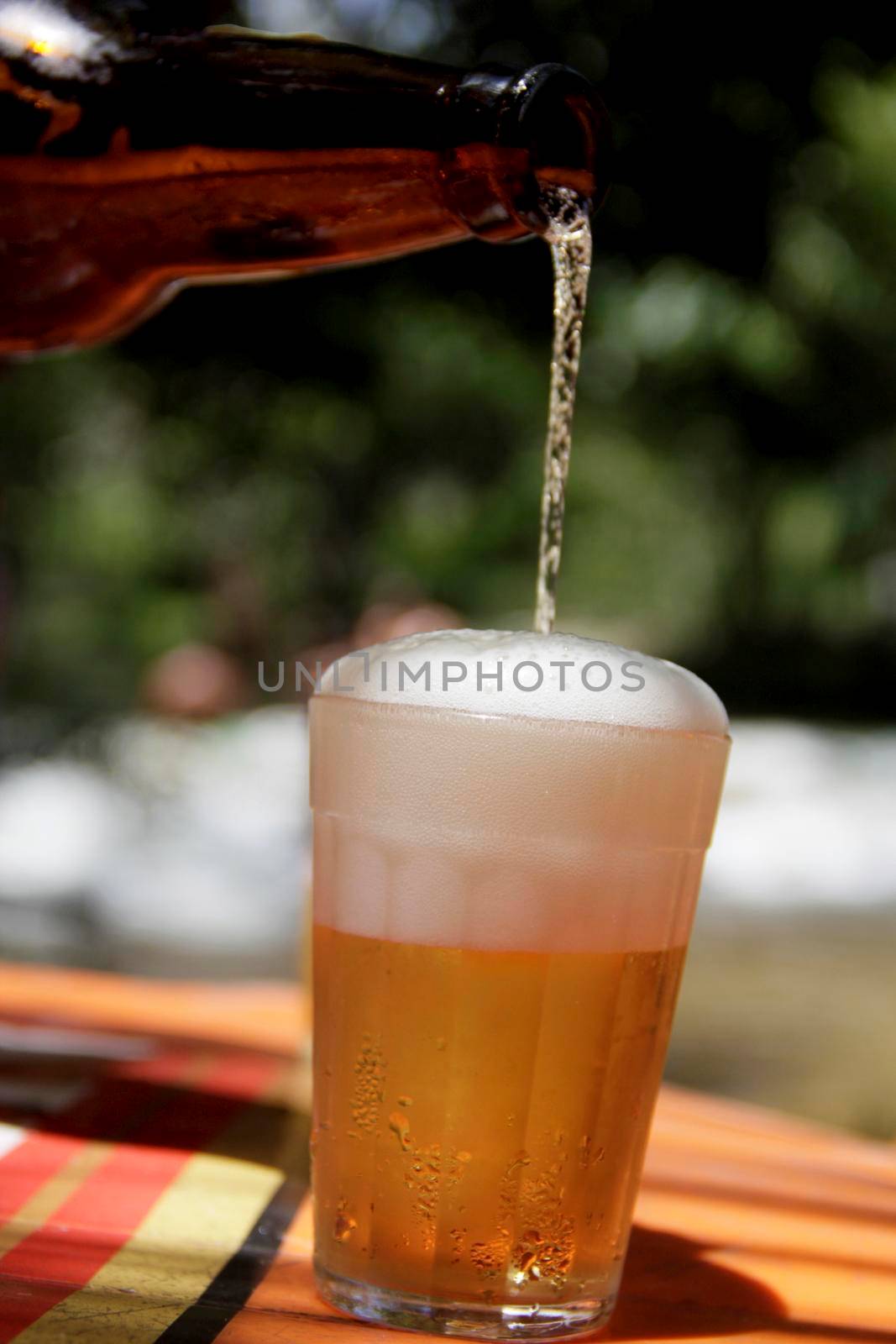 salvador, bahia / brazil - december 20, 2014: bottle of beer spilling on the com on a bar table in the city of Salvador.

