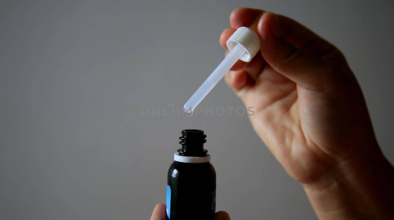 salvador, bahia / brazil - may 7, 2020: hand removes weak medication with the aid of a dropper.
