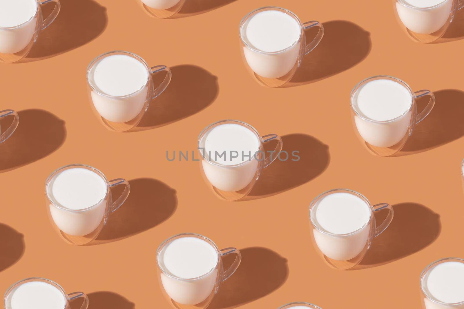 Milk in a glass pattern on a orange colored background, dairy diet concept . High quality photo